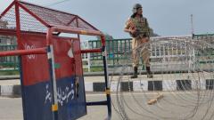A security personnel stands guard on a street during a lockdown in Srinagar on Sunday. A security personnel stands guard on a street during a lockdown in Srinagar on Sunday.